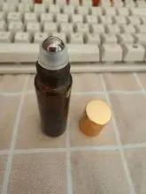 Frasco roll-on de vidro âmbar de 10ml com rolos de aço e tampa de alumínio dourado, adequado para perfumes de óleos essenciais